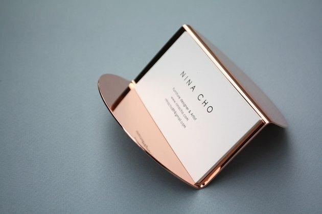 cartão de visita em suporte de ouro rosa