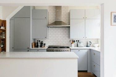 šviesi virtuvė su minimalistinėmis viržių pilkomis spintelėmis
