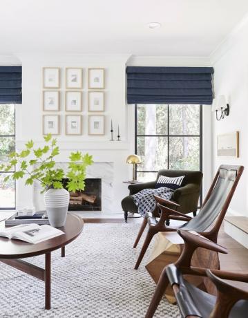 تصميم غرفة عائلية عصرية مشرقة من قبل إميلي هندرسون مع طاولة خشبية بيضاوية وكراسي جلوس جلدية مطابقة.