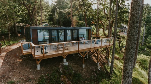 Moderne prefab woning voor zeecontainers op een heuvel met bomen