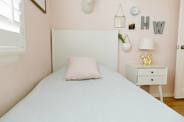 Guia de organização do quarto infantil em quarto feminino rosa com mesa de cabeceira branca
