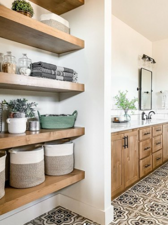 Moderne boerderijbadkamer met open planken, tegelvloer met patroon, houten kasten.