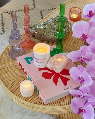mesa de centro decorada com velas coloridas, livros e flores