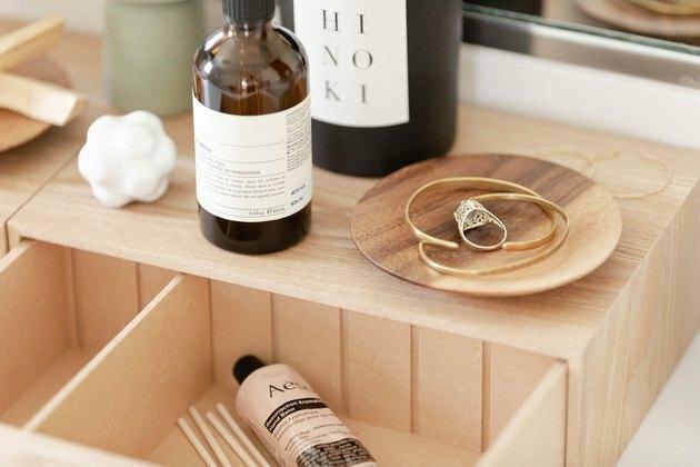 idea di arredo bagno con scatola di legno sul piano di lavoro per riporre gli oggetti essenziali del giorno