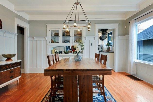 غرفة طعام مع أرضيات خشبية وطاولة مع ثريا