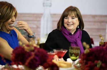 Ina Garten, pukeutunut musta toppi ja violetti huivi, istuu Hoda Kotbin vieressä The Today Shown juhlapöydässä