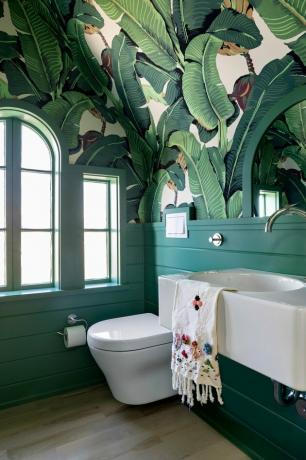 modern toilet in groene badkamer met bananenpalm print behang