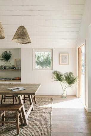 natuurlijk decor in witte eetkamer met palmen in een vaas