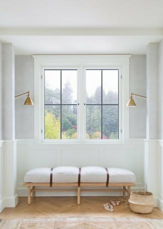 ردهة بيضاء مع مقعد بسيط للنوافذ أسفل النافذة