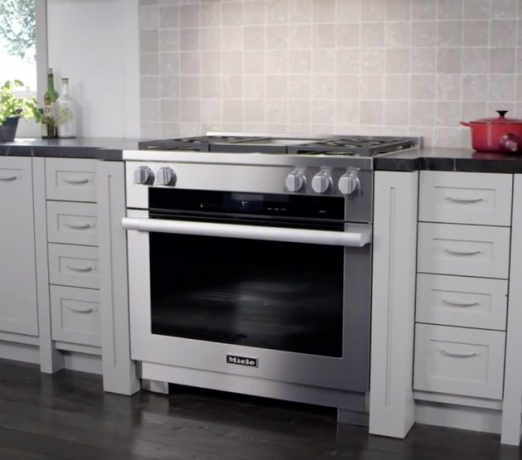 Fogão a gás de aço inoxidável na cozinha com forno holandês vermelho