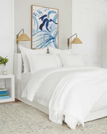 Idéia de cama costeira branca e creme com arte azul moderna e roupa de cama branca