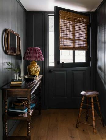Corredor shiplap preto com piso de madeira
