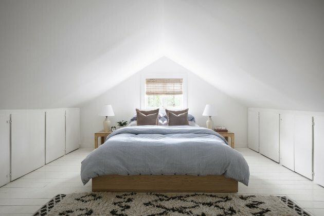 Pequenas idéias no sótão para paredes pintadas de branco e uma cama minimalista com moldura de carvalho.