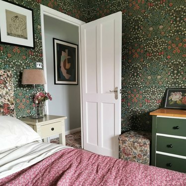 guļamistaba ar zaļām ziedu tapetēm