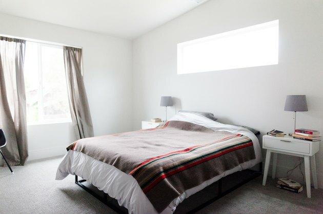 Minimalistisk soveværelse med uldtæppe på sengen