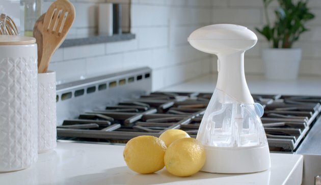 Frasco de spray sanitizante o3waterworks com limões no balcão da cozinha