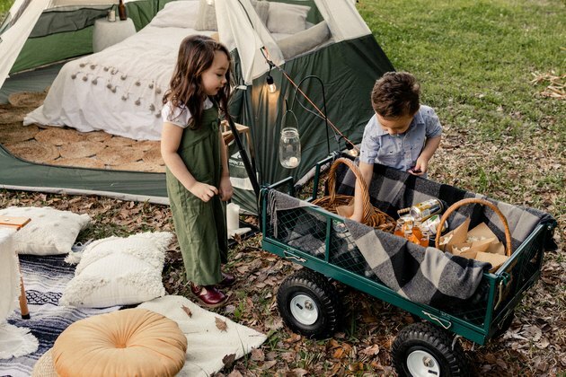 Crianças ao lado da barraca de acampamento ou " glamping"