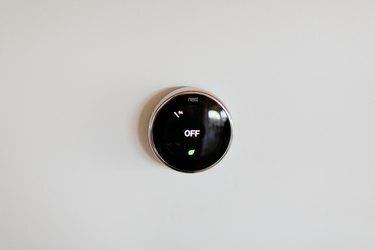 Un thermostat Nest sur un mur blanc.