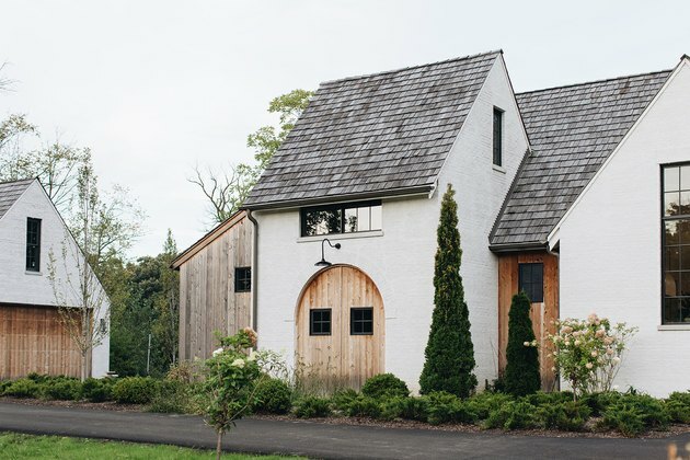 exterior de casa branca com portas de madeira e telhado cinza