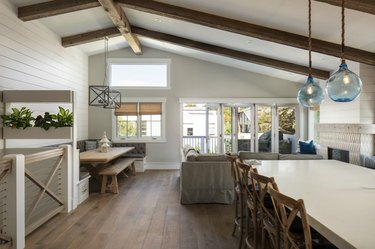 Keuken met tafels en stoelen met gewelfd plafond en witte accentmuur