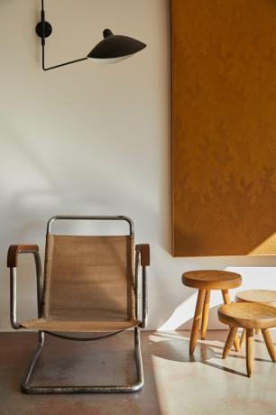 Quarto em estilo Bauhaus com arandela moderna e cadeira Bauhaus