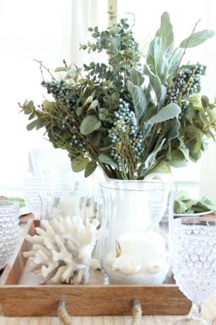 Decoração de outono costeira com peça central com flores de outono e conchas brancas