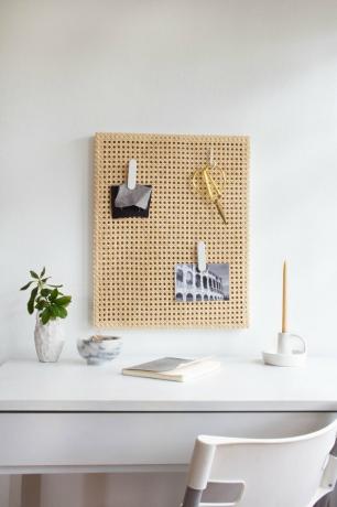 Quadro de notas de cana sobre mesa branca com planta e vela