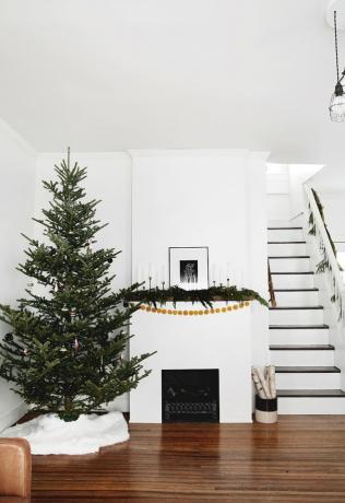 witte woonkamer met Scandinavische kerstboom en open haard