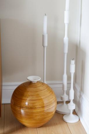Lilin putih tinggi di lantai dengan vas