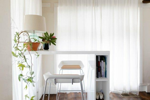 fehér széklet és asztal a növény és a lámpa a közelben