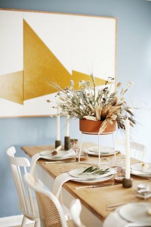 Gedroogde bloemen vallen middelpunt met terracotta vaas in de moderne eetkamer