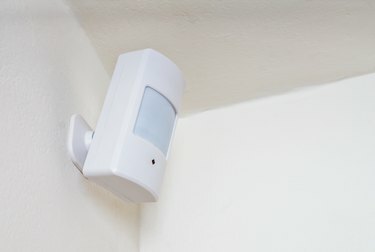 Сензор за движение или детектор за система за сигурност, монтирани на стена.