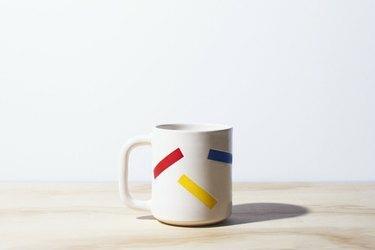 caneca branca com padrão colorido