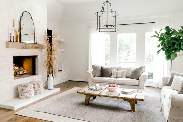 ideia de quarto familiar de casa de fazenda branca com lareira e móveis brancos