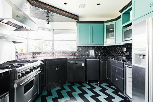 Uma cozinha arrojada com piso e armários em preto turquesa